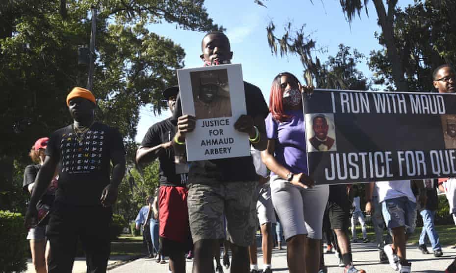 Demonstrators march through a neighborhood in Brunswick, Georgia, to demand answers in the death of Ahmaud Arbery.