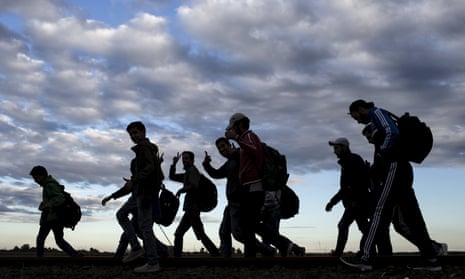 Migrants walk along rail tracks to a collection point in  Hungary