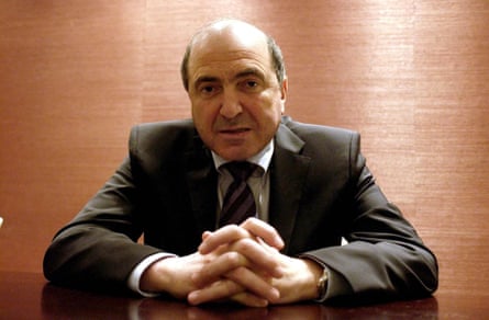 Portrait of Boris Berezovsky, his hands clasped together, sitting at a desk
