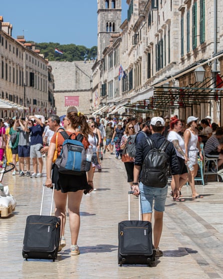 Tourists pull suitcases through Dubrovnik’s old town in July 2023.