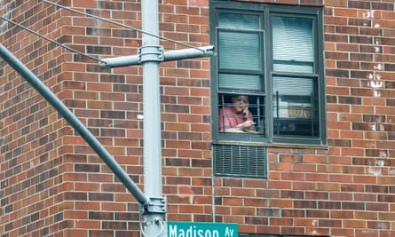 A woman leans out of her window to smoke in New York earlier this month.