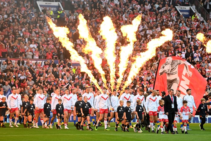 The players of St Helens and Leeds Rhinos take to the pitch.