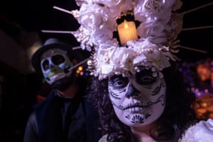 People dressed as Catrinas visit an altar set up for the Day of the Dead festivities in the Santa Anita neighbourhood of Saltillo