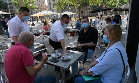 People wearing masks sit at a terrace bar at in Las Ramblas in Barcelona.