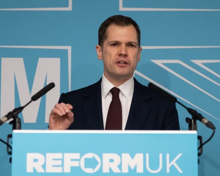 Robert Jenrick speaks in front of a Reform UK podium at a news conference