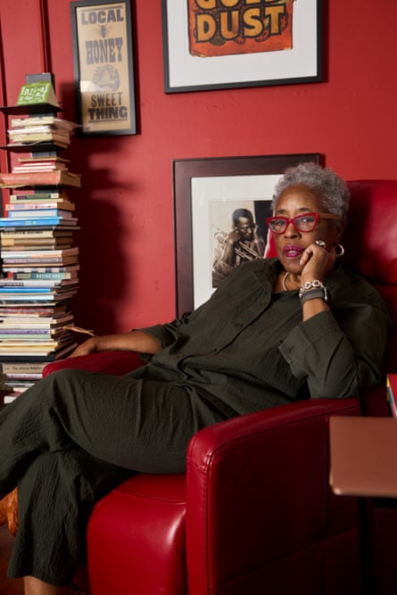 a woman with red glasses sits in a red chair
