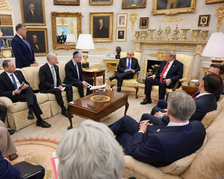 men in suits sit in a room
