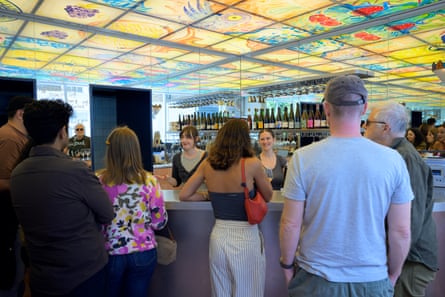 People wait at The Dreamery in north London which colourful artwork on the ceiling.