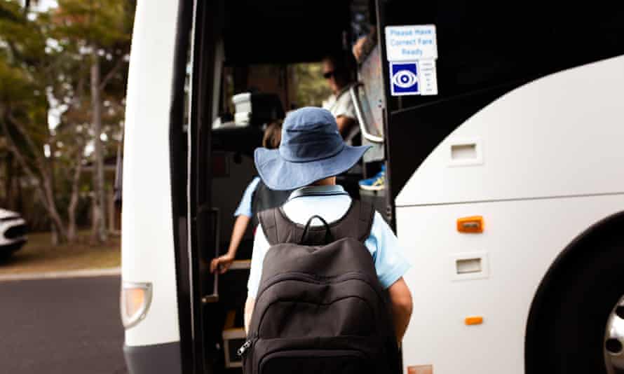 A schoolboy boards the bus.