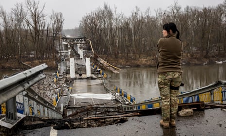 A Ukrainian soldier surveys a blown bridge in the Siverskiy-Donets river on 27 February in Bogorodychne, Ukraine. 