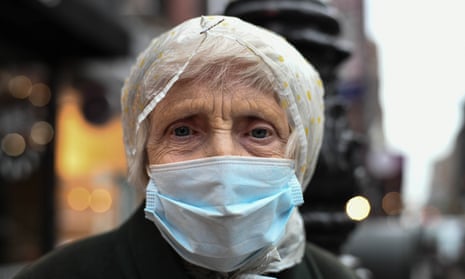 An older woman wears a mask as she comes outside for the nightly 7pm clapping for essential workers in New York City last month.