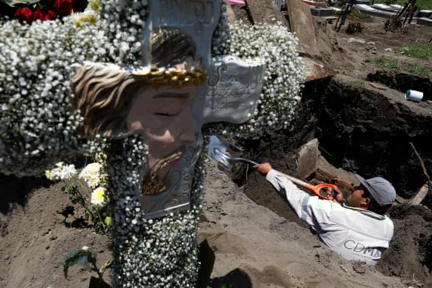 A cemetery worker digs the grave for the burial of a man who died of coronavirus diseas at the San Lorenzo Tezonco cemetery in Mexico City.