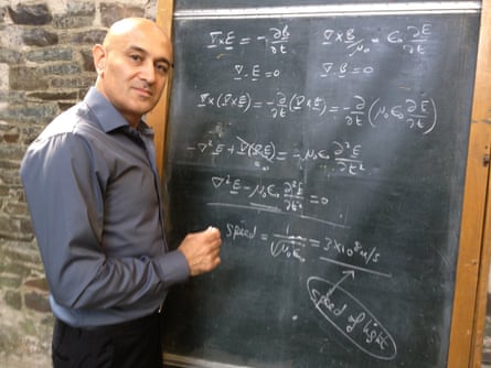 Jim Al-Khalili next to a chalkboard on which he has written equations