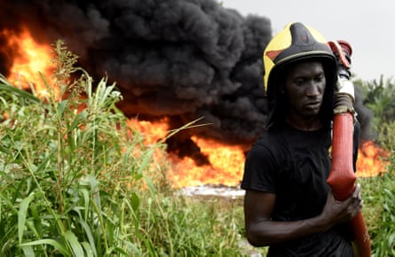 A firefighter works to put out the fire from a ruptured oil pipeline near Lagos.
