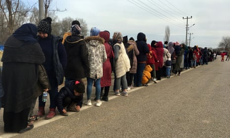 Refugees queue for food aid as they wait at Turkey's Pazarkule border crossing with Greece in March 2020.