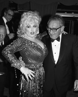 Kissinger stares at the décolletage of a buxom blonde woman in a spangly dress