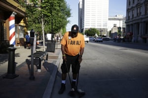 Joseph Robinson sweeps the street before the funeral procession begins