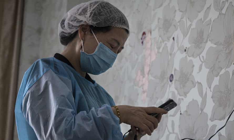 A physiotherapist uses an iPhone in a private obstetric hospital on February 24, 2020 in Wuhan, China.