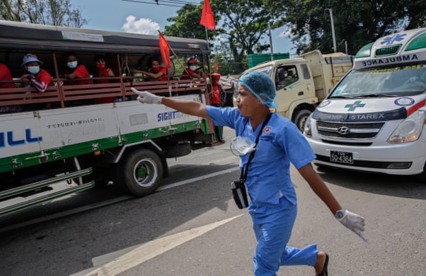 A health worker tries to make way for an ambulance to pass through an election campaign rally in Yangon, Myanmar, on 25 October 2020.
