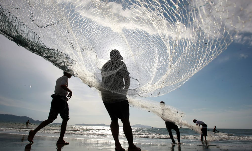 A group of fishermen pulling fishing net in the coastal area of Kampung Jawa village, Aceh, Indonesia.