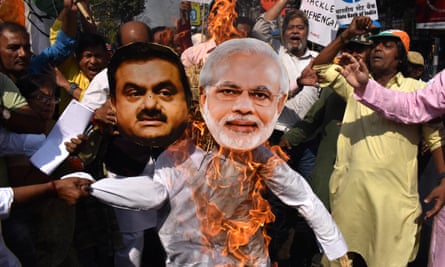 People burn effigies of Gautam Adani and Narendra Modi during a protest in Kolkata.