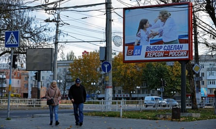 People walk past a poster that reads ‘The choice is made. Kherson is Russia’ last week