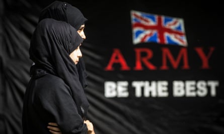 Female Muslim pupils next to a sign that says Army be the Best