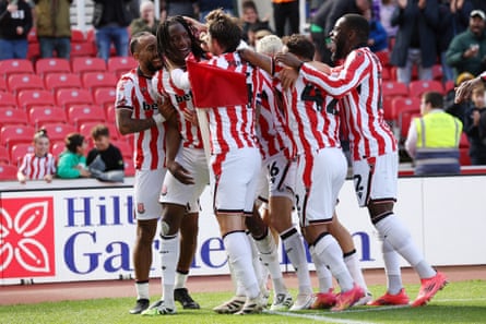 Bosun Lawal celebrates scoring Stoke’s winner against Birmingham with a crowd of teammates