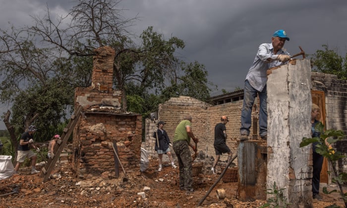 Serhiy (R), together with young volunteers from the ‘Repair Together’ initiative, and his parents who lived in this house clean the rubble from their home that was destroyed during the Russian invasion, at Ivanivka village, Chernihiv region. EPA/ROMAN PILIPEY