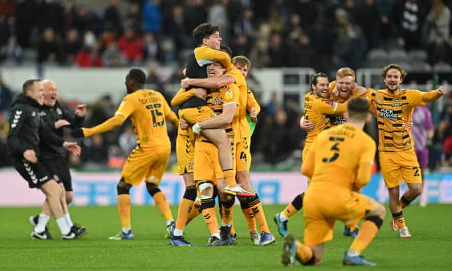 Cambridge United’s players celebrate on the pitch after the English FA Cup third round victory over Newcastle United.