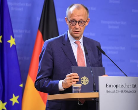 Chancellor Friedrich Merz speaks at a podium between EU and German flags