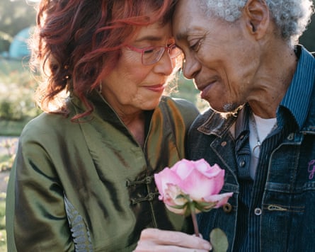 Beverly Glenn-Copeland and his wife Elizabeth embracing, with Elizabeth holding a rose