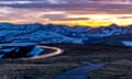 A dusk view of a section of the Trail Ridge Road winding through the snow-covered peaks of the Rockies