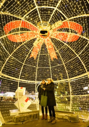 La gente es vista por una instalación de luz instalada en Revolution Fighters Square para las vacaciones de invierno.