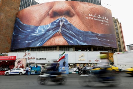 people drive past a billboard