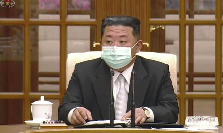 زعيم كوريا الشمالية كيم جونغ أون يرتدي قناع الوجه على التلفزيون الحكومي خلال اجتماع يعترف بأول حالة في البلاد لـ Covid-19