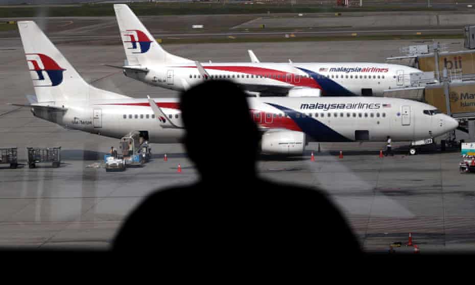 A passenger looks at Malaysia Airline planes from the viewing gallery at Kuala Lumpur International Airport.