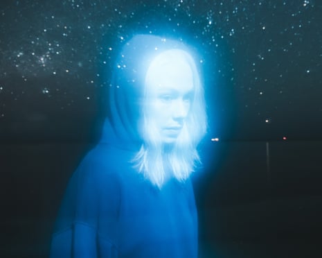 A blue-tinted photograph of the musician Phoebe Bridgers surrounded by stars
