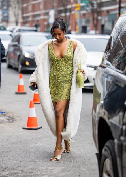 A guest in a green mini dress heads to the Cult Gaia show at New York fashion week.