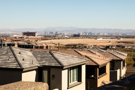 houses in foreground in front of desert, with strip in the distance and then mountains