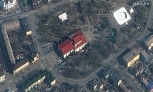 A satellite image shows Mariupol Drama Theatre before the bombing with the word “children” in Russian written in large white letters on the pavement in front of and behind the building in Mariupol.