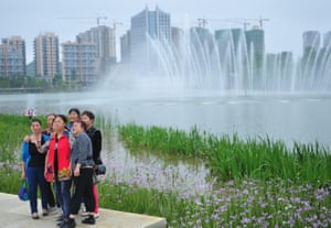 Tourists pose for a photo in Quanhu lake park in Guiyang.