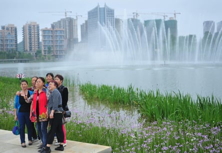 Tourists pose for a photo in Quanhu lake park in Guiyang.