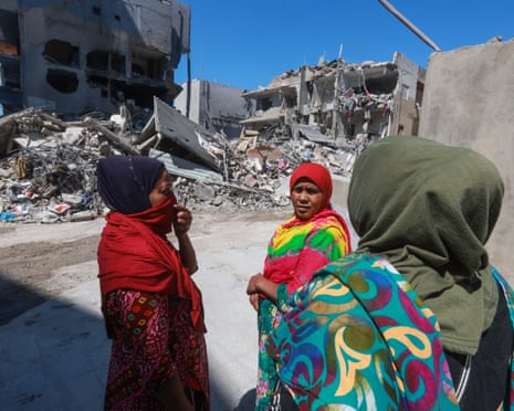 People gather at the site of an overnight Israeli strike in the southern Lebanese city of Tyre on Saturday