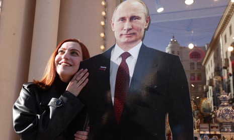 Smiling woman poses beside a life-size cardboard cut-out of Vladimir Putin.