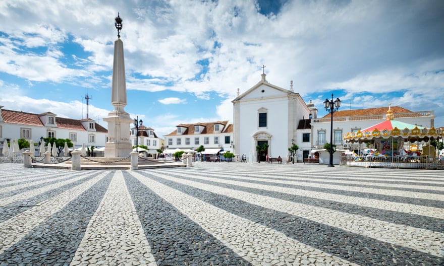 Painted stripes on a pebbled square radiate out from a statue