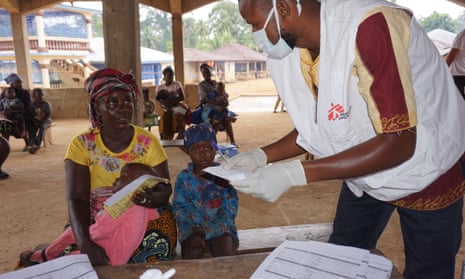 A Médecins Sans Frontières health worker tends to a mother and her child at a mobile clinic in Sierra Leone
