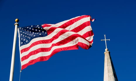 American flag and church steeple against blue sky