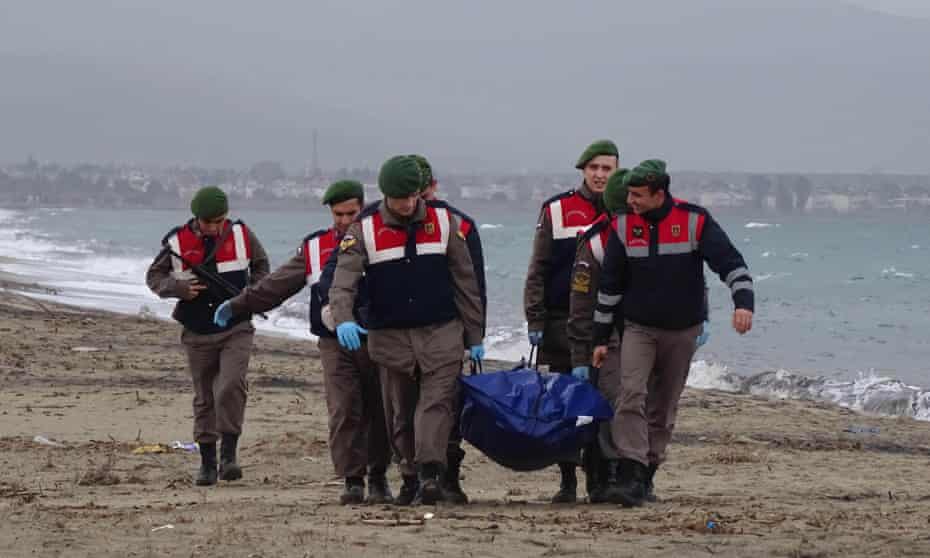 Officers carry the body of a refugee that washed up on the shore in Izmir, Turkey