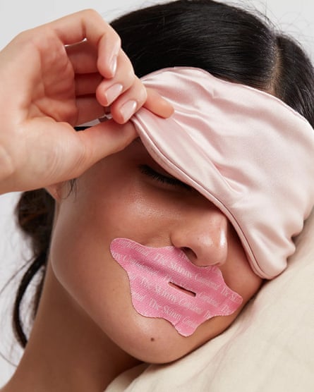A woman with tape over her mouth and an eye mask